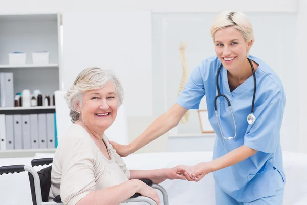 Friendly nurse holding senior patients hand — Stock Photo, Image