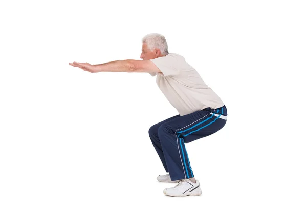 Senior man doing a squat — Stock Photo, Image