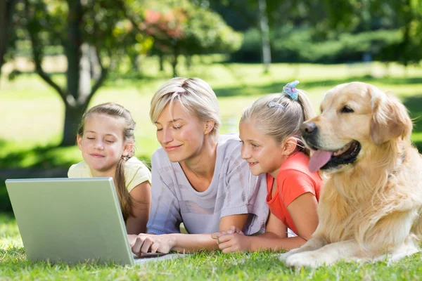 Happy family using laptop in the park — Stock Photo, Image