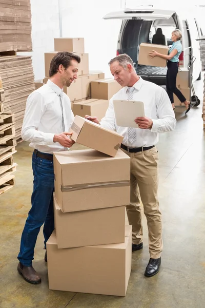 Warehouse managers checking their list — Stock Photo, Image