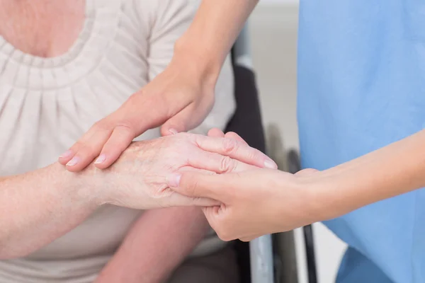 Infirmière contrôlant la flexibilité du poignet des patients — Photo