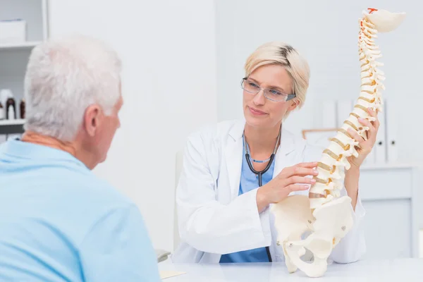 Médico explicando columna anatómica al paciente — Foto de Stock