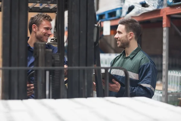 Smiling warehouse workers talking together — Stock Photo, Image