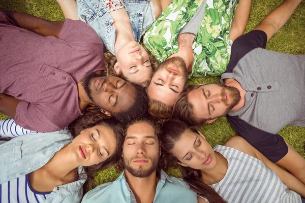 Happy jonge vrienden liggen op gras — Stockfoto