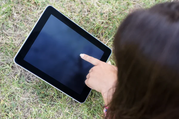 Vrouw met behulp van Tablet PC in park — Stockfoto