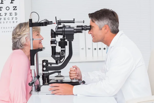 Optiker untersucht Patient durch Spaltlampe — Stockfoto