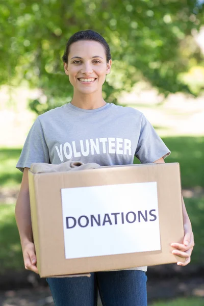 Bonito voluntário com caixas de doação no parque — Fotografia de Stock