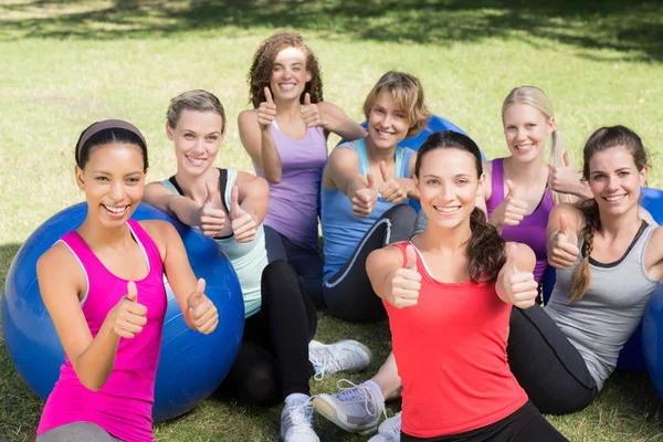 Fitness group smiling at camera in park — Stock Photo, Image