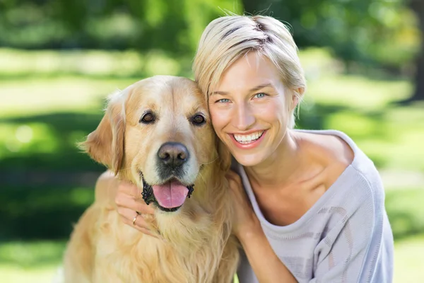 Pretty blonde with dog in the park — Stock Photo, Image