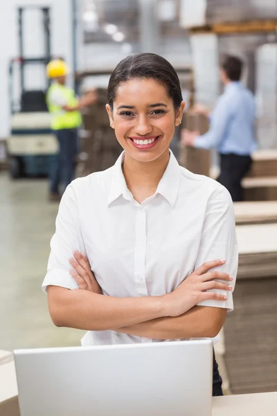 Female manager with arms crossed in warehouse — Stock Photo, Image