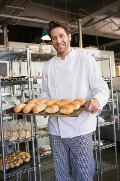 Baker showing tray with bread — Stock Photo, Image