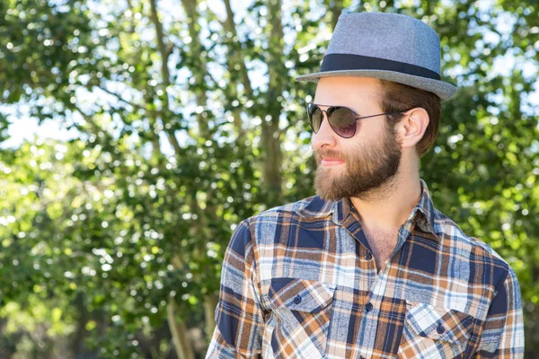 Guapo hipster sonriendo en el parque —  Fotos de Stock