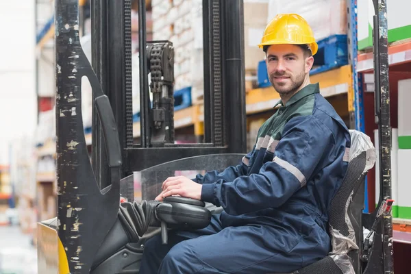 Driver operating forklift machine in warehouse — Stock Photo, Image