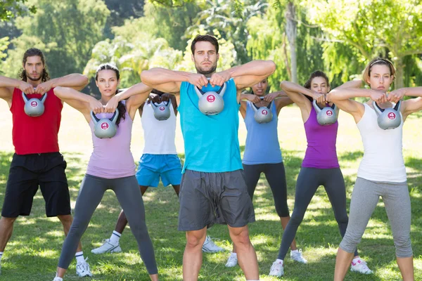 Fitness-gruppen arbetar i parken med vattenkokare klockor — Stockfoto