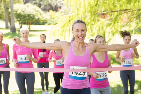 Smiling women running for breast cancer awareness — Stock Photo, Image