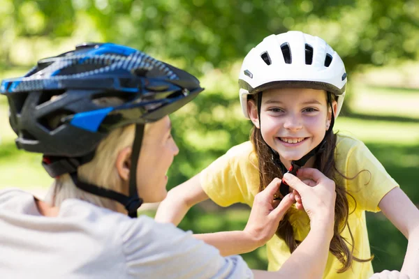 Madre allegando figlie casco da ciclismo — Foto Stock