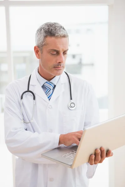 Médico usando laptop sorrindo — Fotografia de Stock