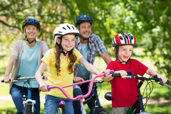 Счастливая семья на велосипеде в парке — стоковое фото