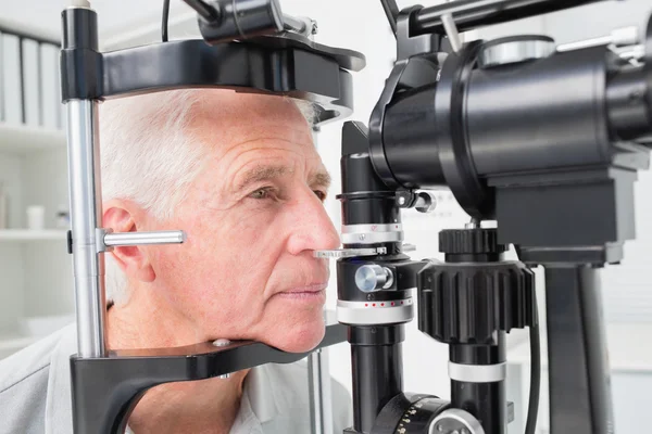 Man looking into slit lamp — Stock Photo, Image