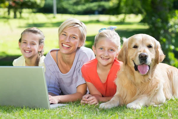 Family and their dog smiling at camera — Stock Photo, Image