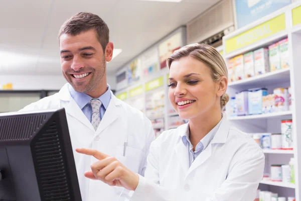 Team av farmaceuter tittar på en dator — Stockfoto