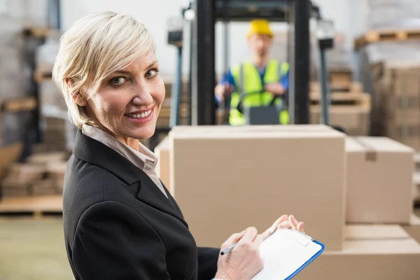 Warehouse manager writing on clipboard — Stock Photo, Image