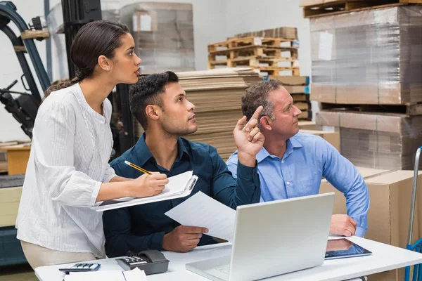 Warehouse manager pointing something to colleagues — Stock Photo, Image