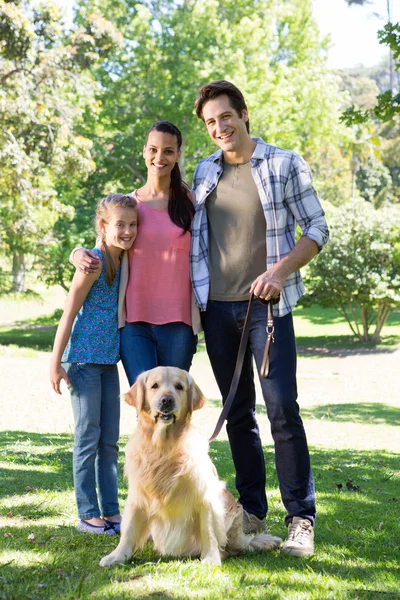 Família feliz passeando seu cão no parque — Fotografia de Stock