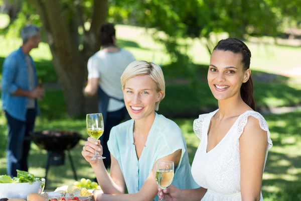 Glückliche Freunde beim Trinken im Park — Stockfoto