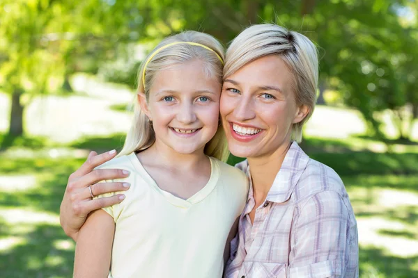 Blond med datteren i parken. – stockfoto