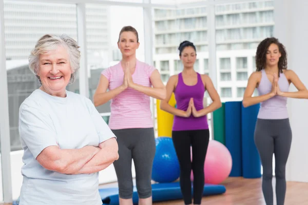 Senior woman with arms crossed standing in gym — Stock Photo, Image