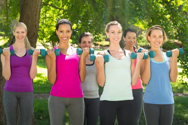 Fitness group lifting hand weights in park — Stock Photo, Image