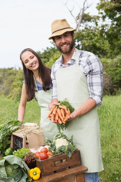 Paar verkoop van biologische groenten op markt — Stockfoto