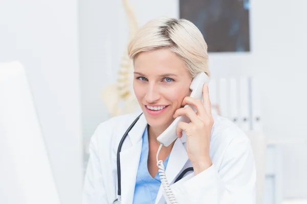 Kobieta lekarz za pomocą ziemi liniami telefonicznymi w klinice — Zdjęcie stockowe