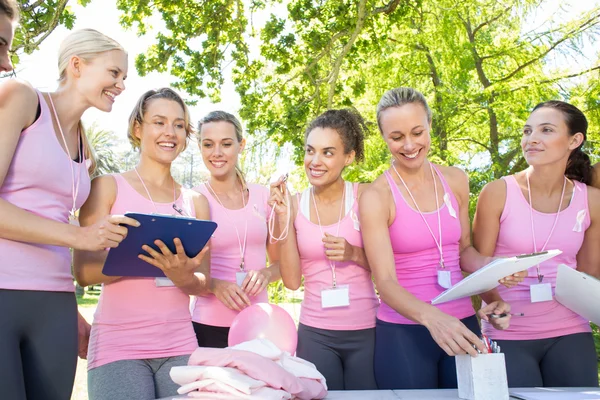 Donne sorridenti che organizzano un evento per la sensibilizzazione sul cancro al seno — Foto Stock