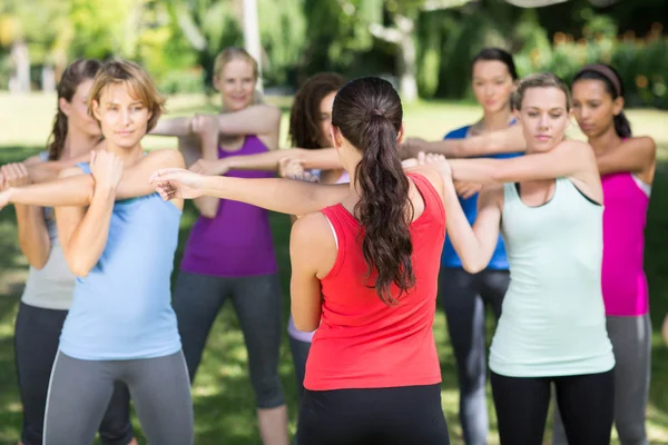 Fitness group warming up in park — Stock Photo, Image