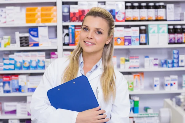 Farmacéutico sonriente sujetando portapapeles — Foto de Stock