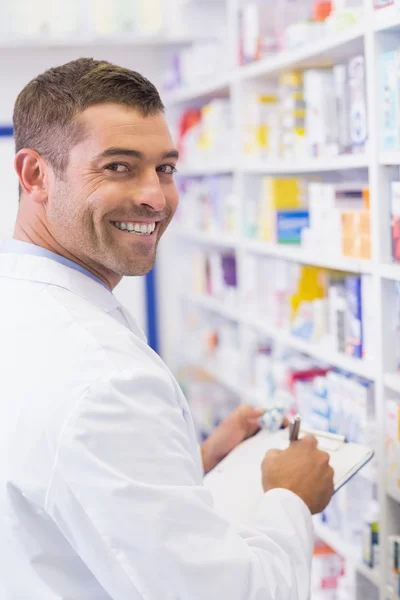 Feliz farmacêutico escrevendo na área de transferência — Fotografia de Stock