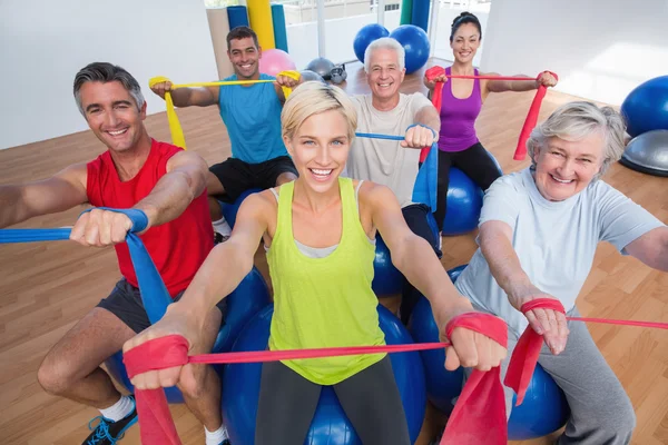 Gente feliz haciendo ejercicio con bandas de resistencia en clase de gimnasia — Foto de Stock