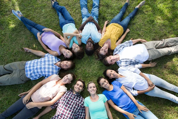 Счастливые друзья в парке лежат в кругу — стоковое фото