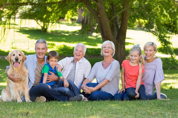 Family smiling at camera with dog — Stock Photo, Image