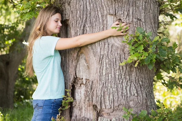 Hübsche Blondine umarmt einen Baum — Stockfoto