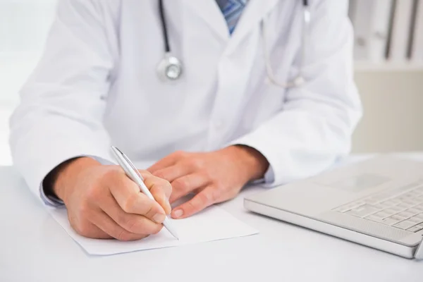 Doctor escribiendo en un bloc de notas — Foto de Stock