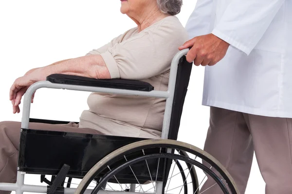 Pchania pacjenta lekarz na wózku inwalidzkim — Zdjęcie stockowe
