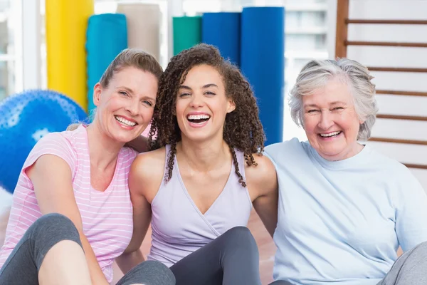 Happy female friends sitting together in gym — Stock Photo, Image