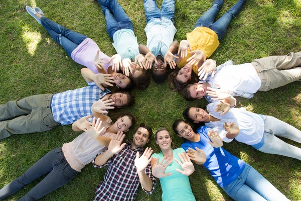 Amigos felizes no parque deitado em círculo — Fotografia de Stock