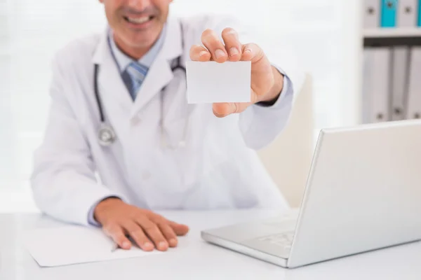 Médico sorridente mostrando um branco — Fotografia de Stock