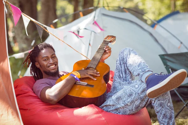 Hipster avkopplande på campingen spelar gitarr — Stockfoto