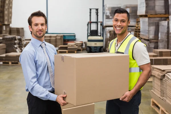 Warehouse worker and manager passing box — Stock Photo, Image