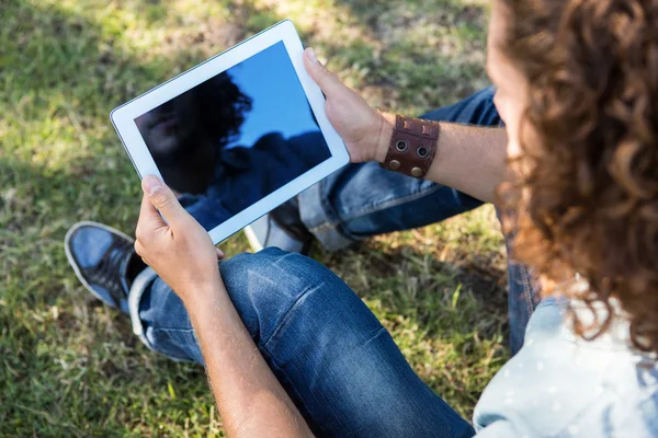 Jeune homme utilisant une tablette dans le parc — Photo